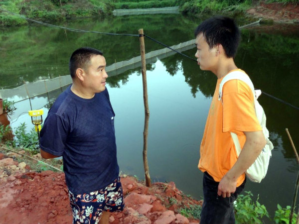队员与养殖户进行泥鳅养殖交流.jpg