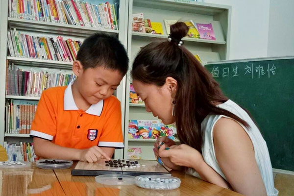 志愿者正和一位小孩子下棋.jpg